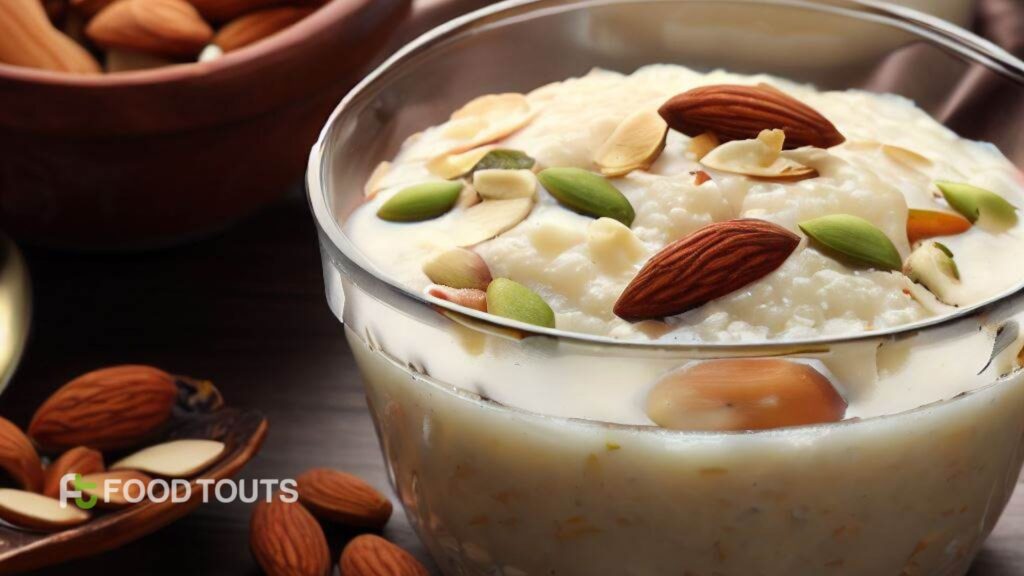A glass bowl with Rice Kheer garnished with almonds and pistachios.