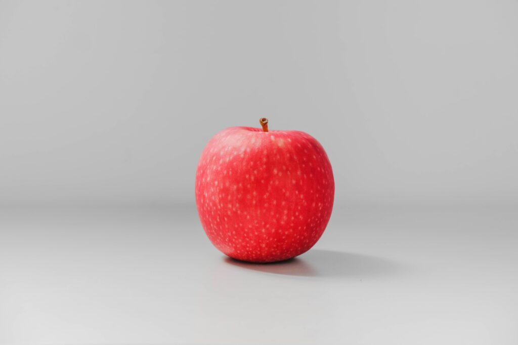 Apple in red color with greyish background